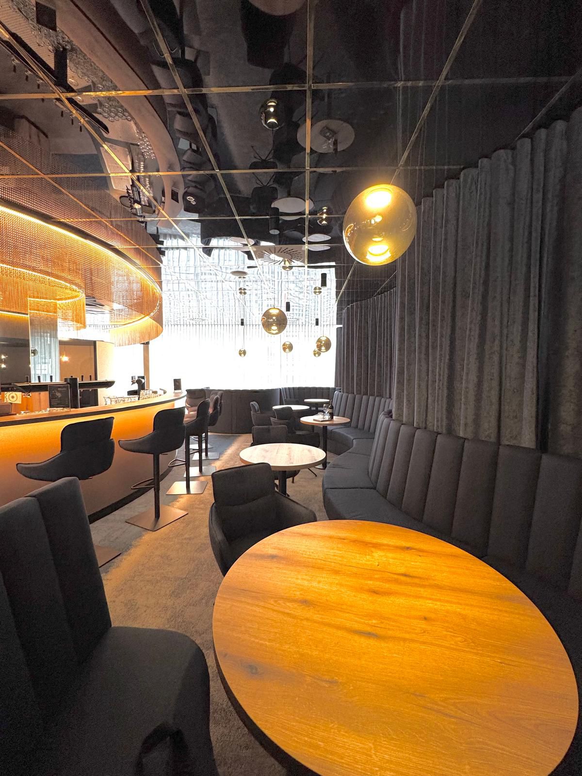 Ein schickes modernes Café mit runden Holztischen und eleganter Beleuchtung